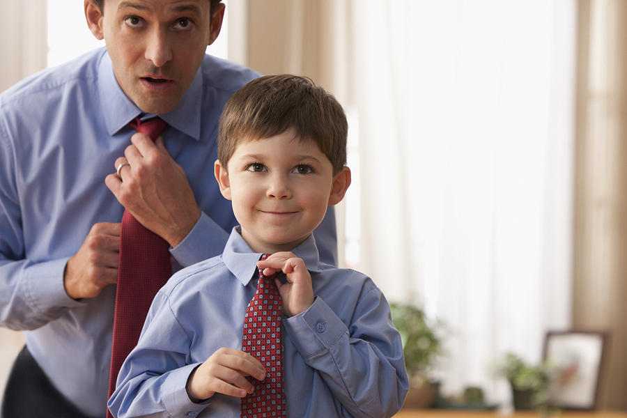 Father and son fixing ties together Photograph by SelectStock