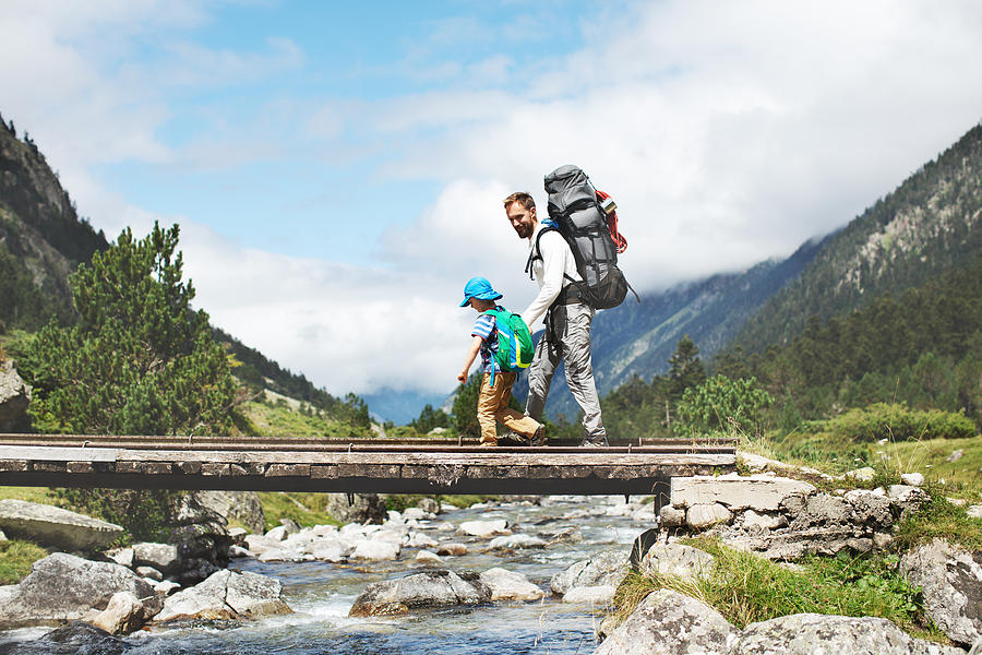 Father and son hiking together in mountains Photograph by Yulkapopkova
