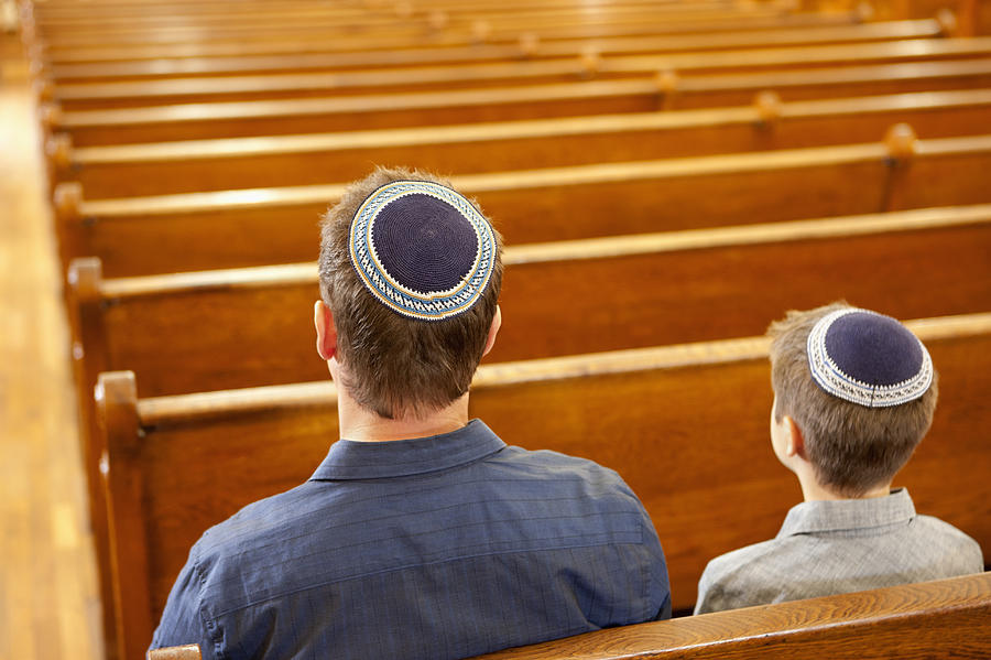 Father and son in yarmulkes sitting in synagogue Photograph by Robert Nicholas