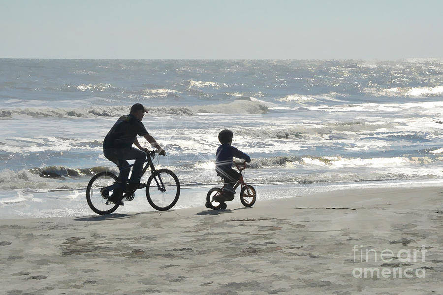 Father and son riding bikes on beach Photograph by Dan Friend