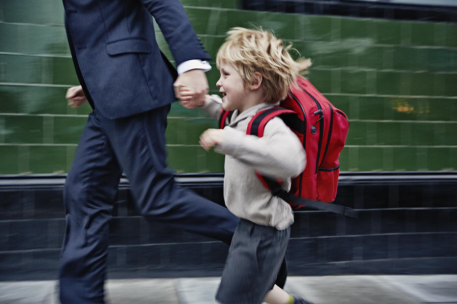 Father and son running to school Photograph by Frank Herholdt
