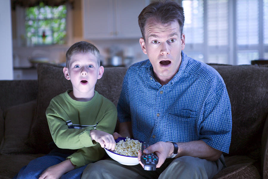 Father and son with remote control and popcorn Photograph by Thinkstock Images
