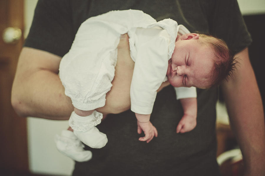 Father holding his newborn baby daughter Photograph by Sally Anscombe