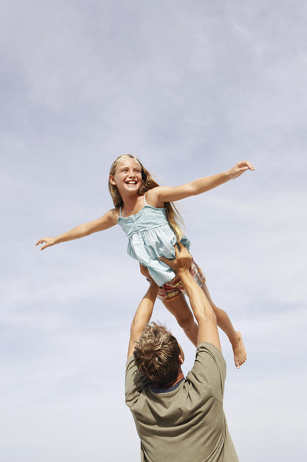 Father lifting daughter in air Photograph by Klaus Tiedge