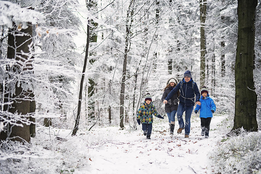 Father with kids running in beautiful winter forest Photograph by Imgorthand