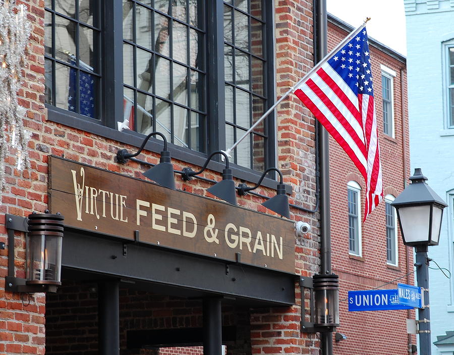 Feed And Grain Store With Our Flag Flying Photograph by James DeFazio