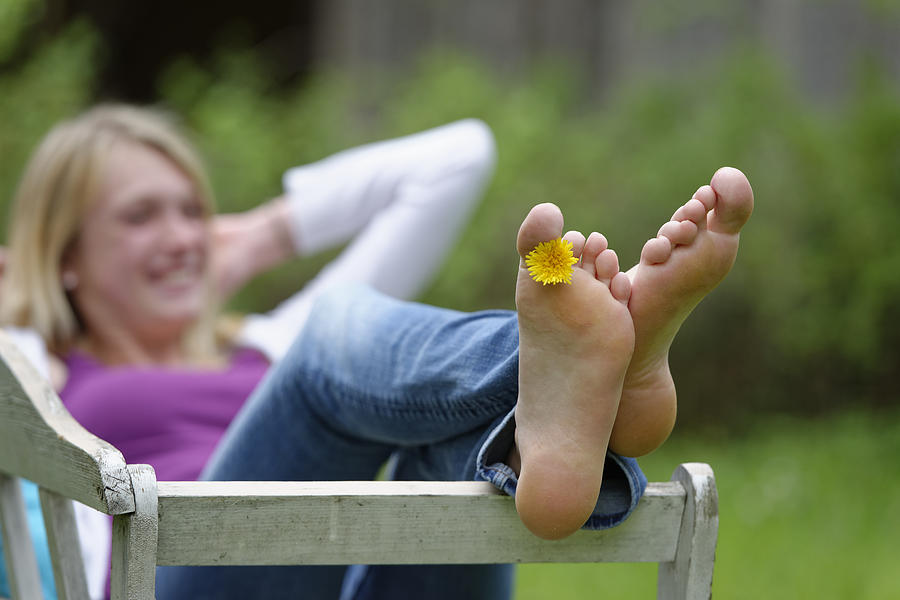 Feet of a woman with dandelion between toes Photograph by Westend61