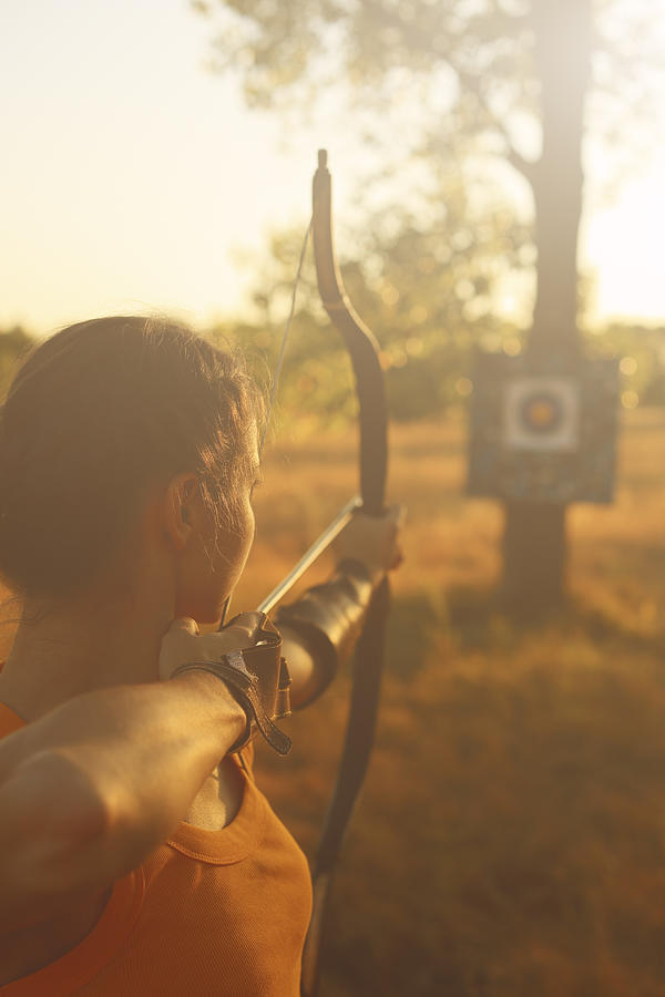 Female archer in the field at sunset Photograph by Myshkovsky