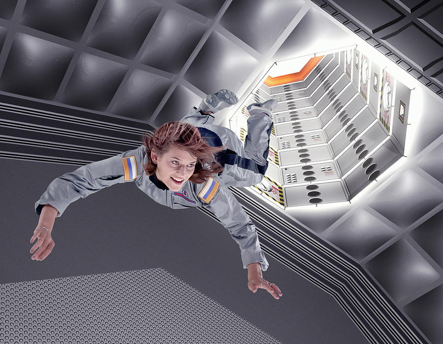 Female astronaut floating in space station (Digital Composite) Photograph by John Lamb