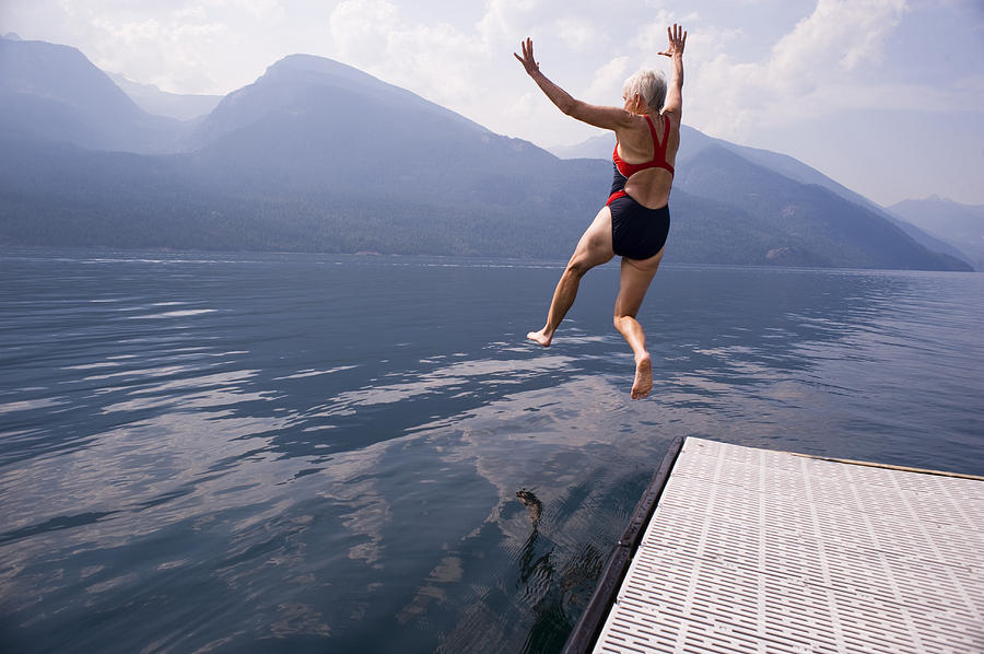 Female Babyboomer Jumping Into Lake Photograph by Ira T. Nicolai