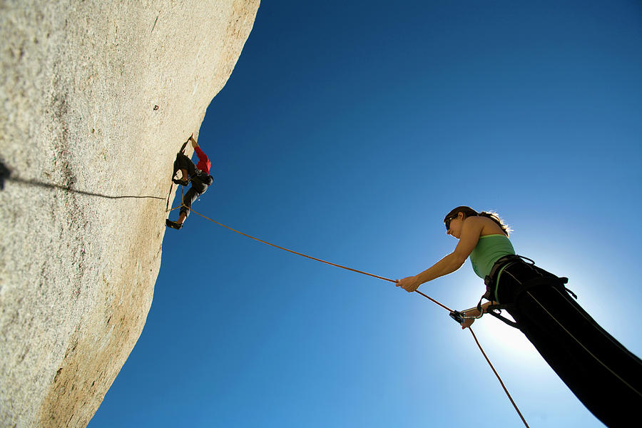 Female Belaying Against Blue Sky Photograph by Corey Rich