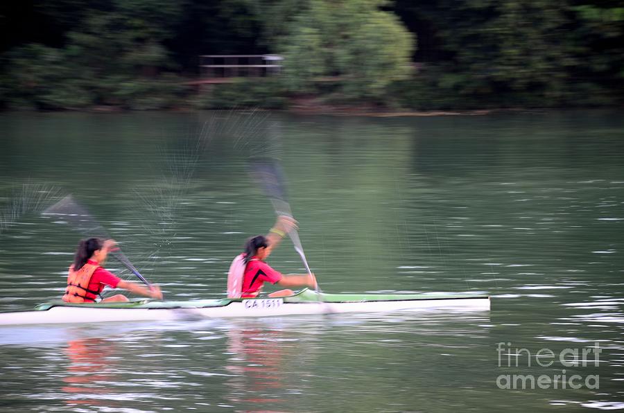 Female canoe paddlers row in lake Photograph by Imran Ahmed