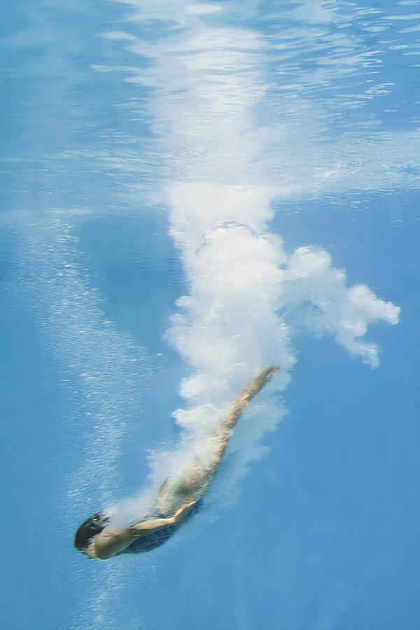Female diver in pool, underwater view, (blurred motion) Photograph by David Madison