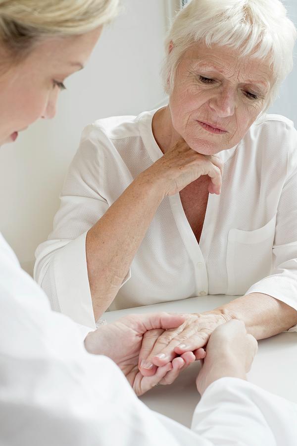 Female Doctor Examining Senior Patient's Hand Photograph by Science ...