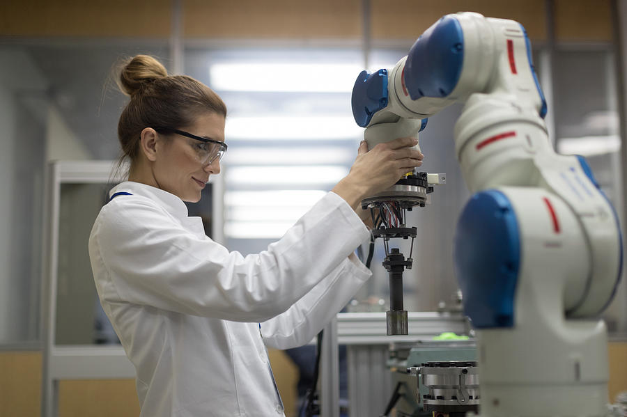 Female engineers working with robotic arm Photograph by Zoranm