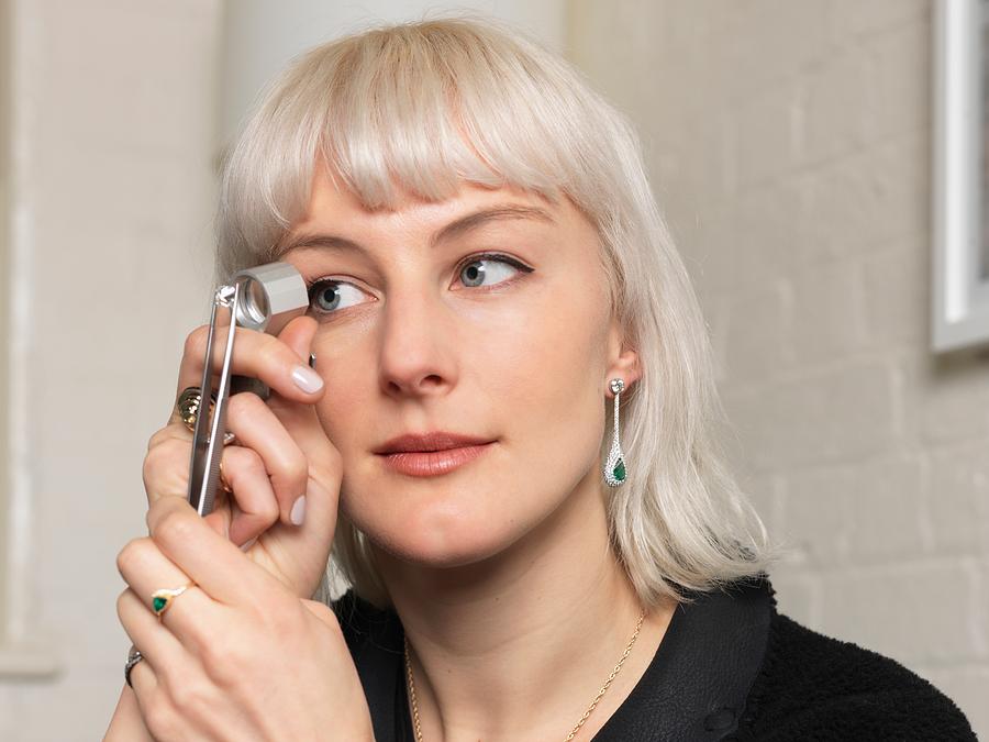 Female jeweler examining diamond using magnifier in jewellery shop Photograph by Elke Meitzel