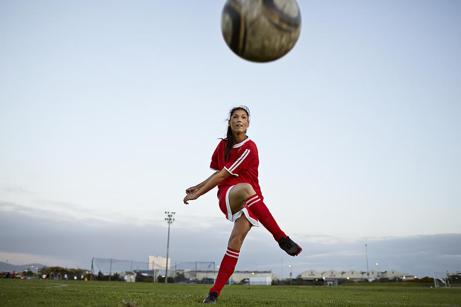 Female soccer player kicking the ball over camera Photograph by Klaus Vedfelt