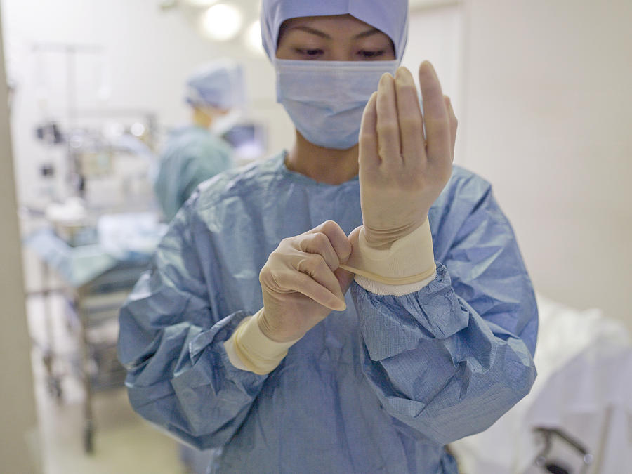 Female surgeon adjusting medical glove in hospital Photograph by Michael H