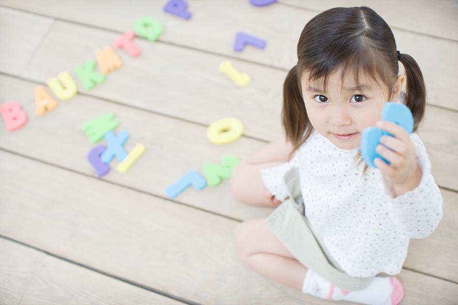 Female toddler playing with educational toys Photograph by Image Source