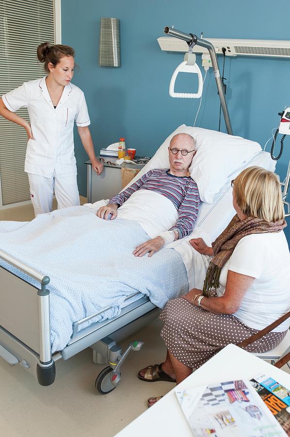 Female Visitor And Nurse Talking To Senior Man Photograph By Arno