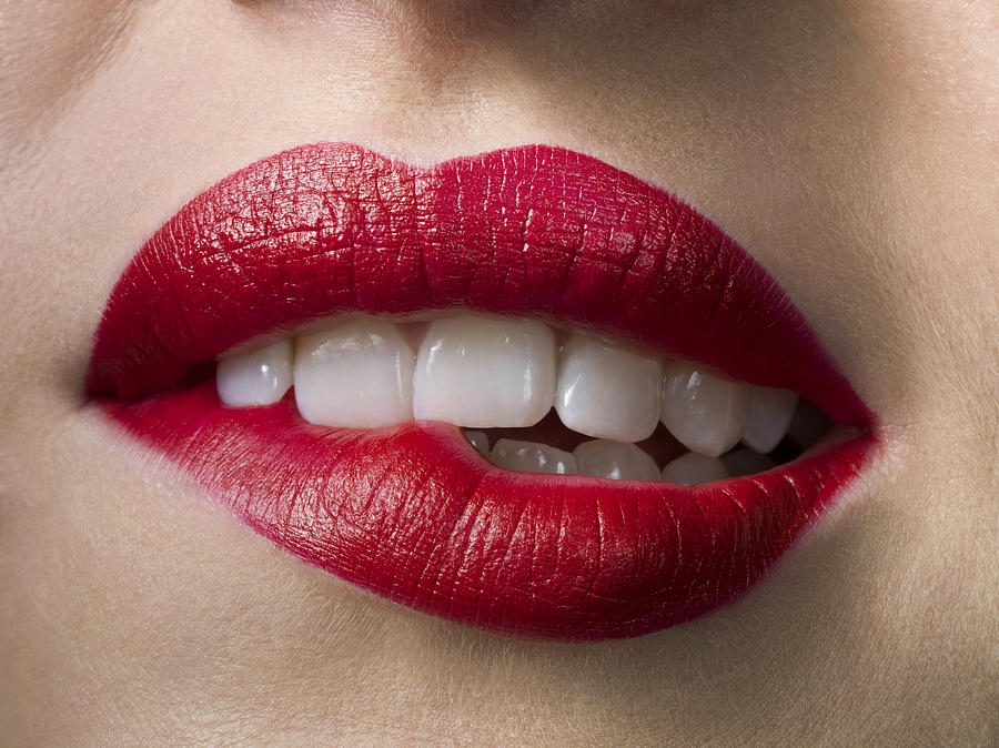 Female with red lipstick, biting lips, close up Photograph by Jonathan Knowles