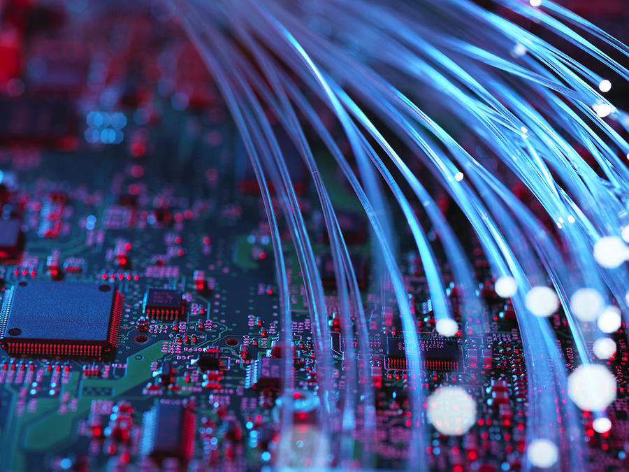 Fibre optics flowing through circuit boards from a laptop computer, close-up Photograph by Rafe Swan