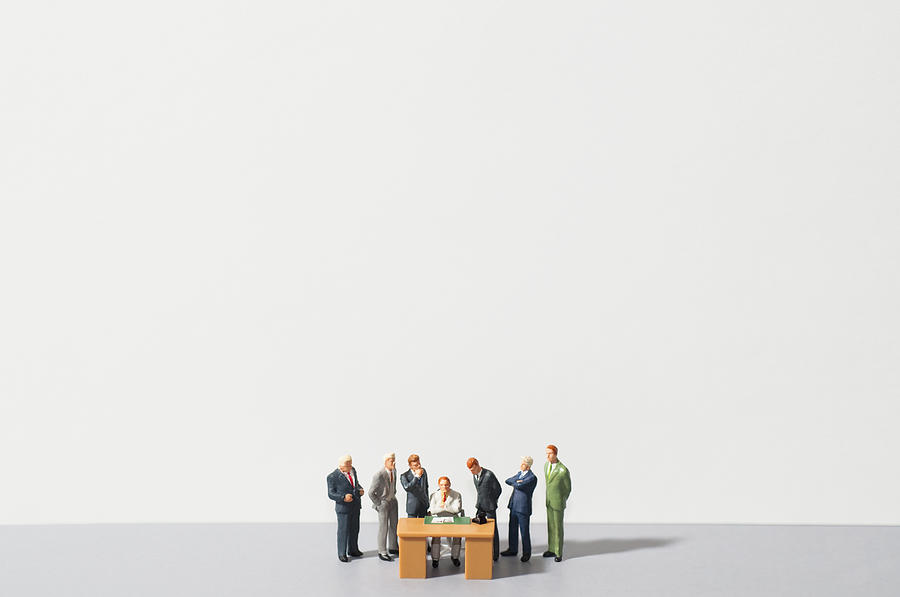 Figurines of people standing around desk Photograph by Antonio M. Rosario