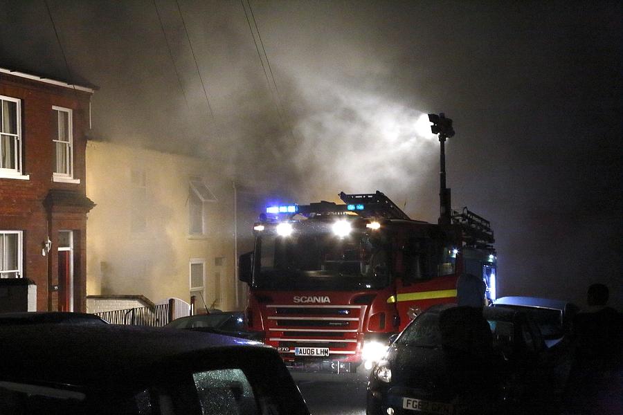 Fire engine attending a house fire by Science Photo Library