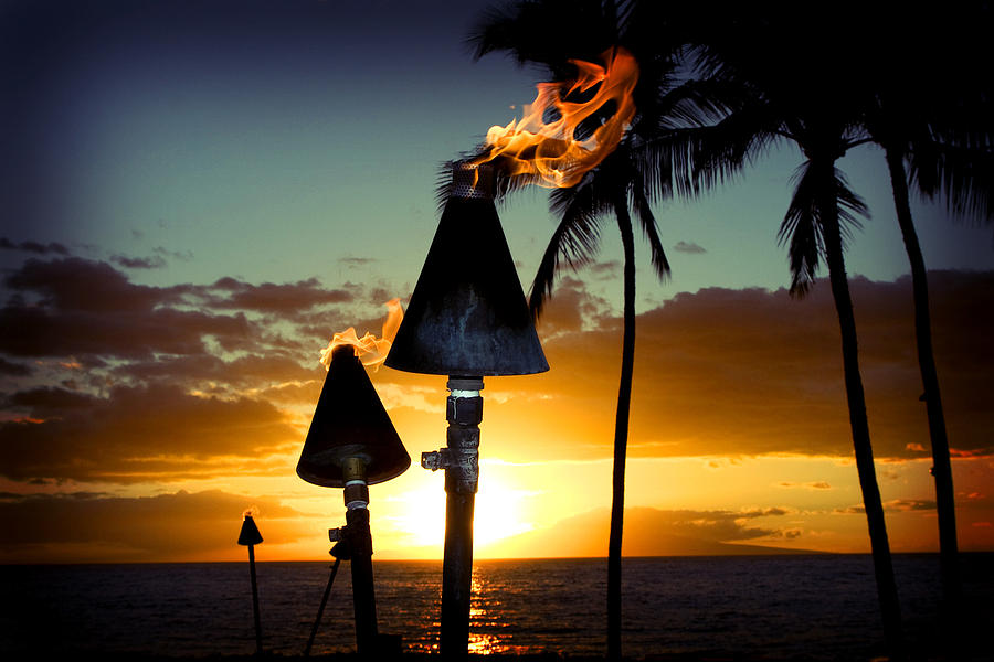 Fire torches against a beautiful island sunset Photograph by Mccaig
