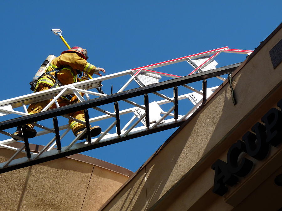 Firefighter Climbing Ladder Photograph by Jeff Lowe