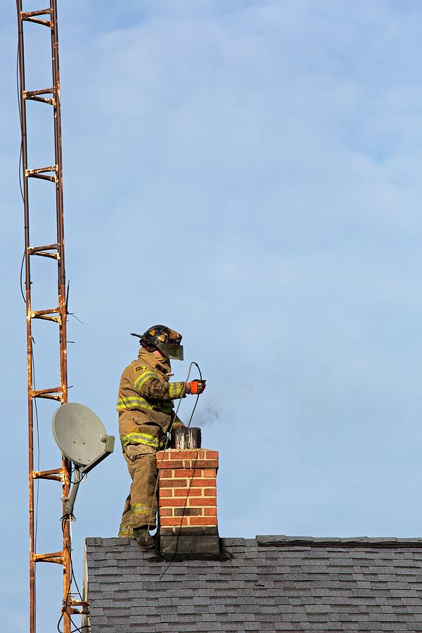 Firefighter Fighting A Chimney Fire Photograph by Jim West