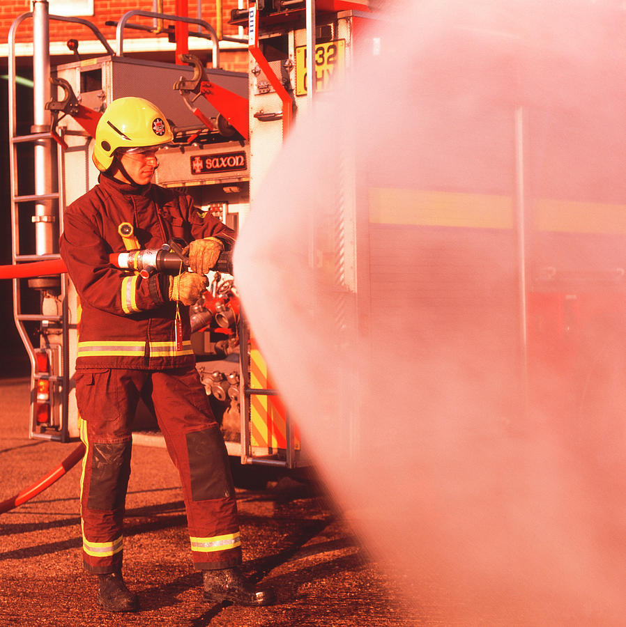 Fire Engine Photograph - Firefighter Using Hose by Simon Lewis/science Photo Library