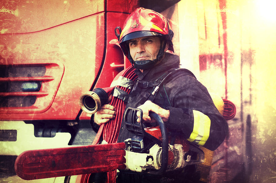 Firefighter with chainsaw and fire hose in the Wings Photograph by SeanShot