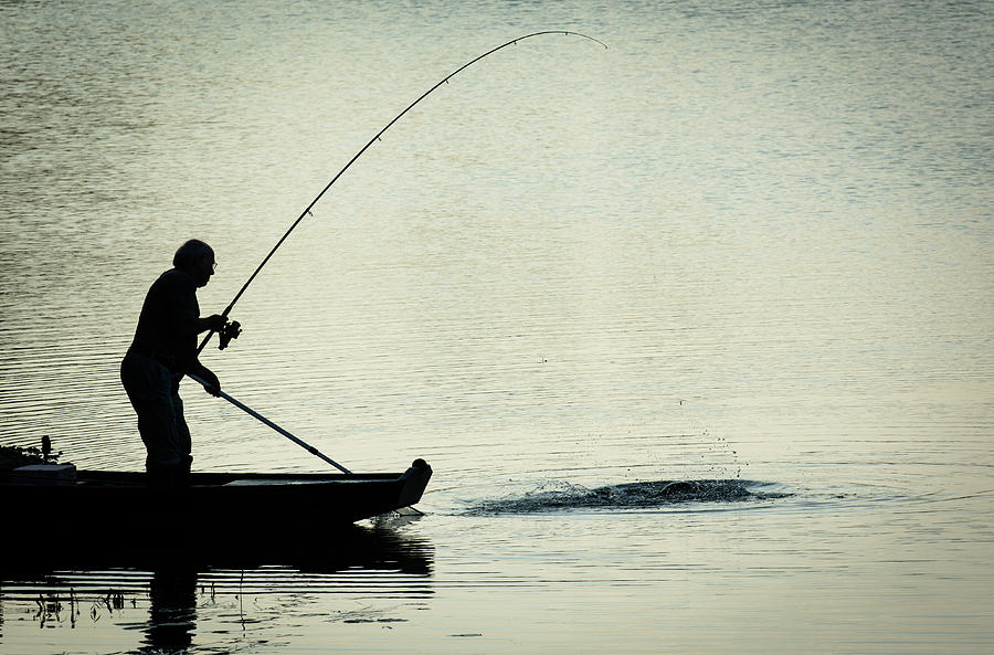 Fisherman Catching Fish On A Twilight Lake Photograph by Andreas Berthold