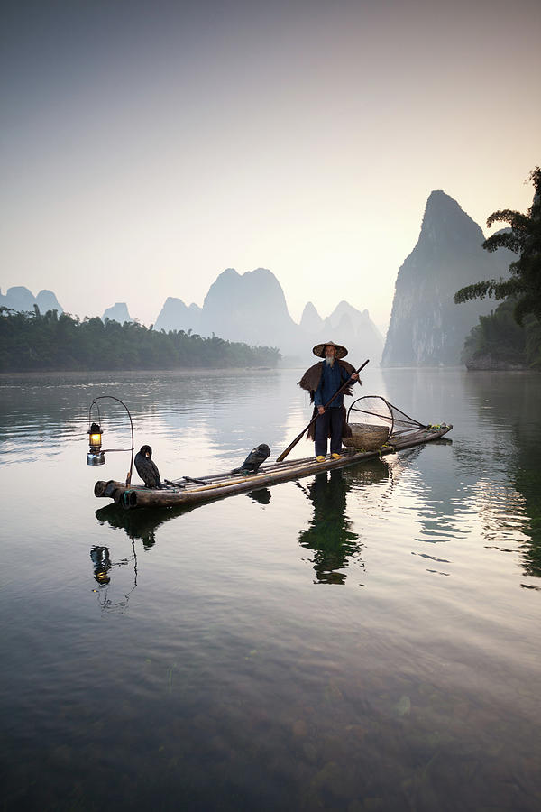 Fisherman With Cormorants On River Photograph by Matteo Colombo