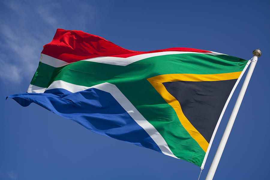 Flag of South Africa blowing in wind against blue sky Photograph by Ramberg