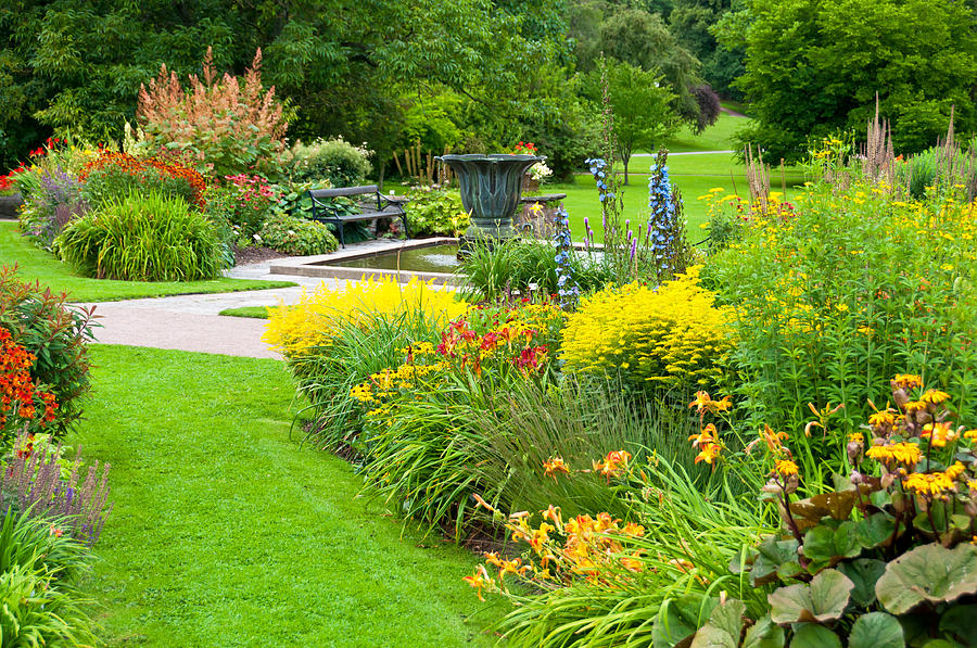 Flowerbeds, lawn and pond in a beautiful park Photograph by Martin Wahlborg