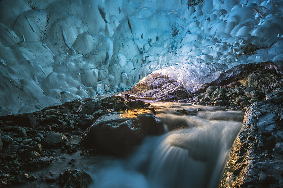 Flowing river inside a crystal ice cave in winter. Iceland. Photograph by © Marco Bottigelli
