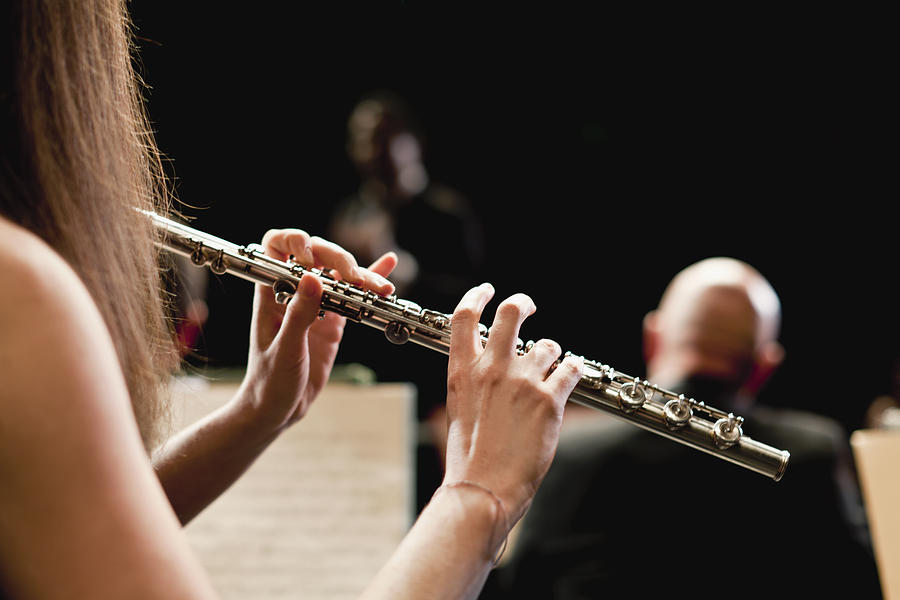 Flute player in orchestra Photograph by Hybrid Images