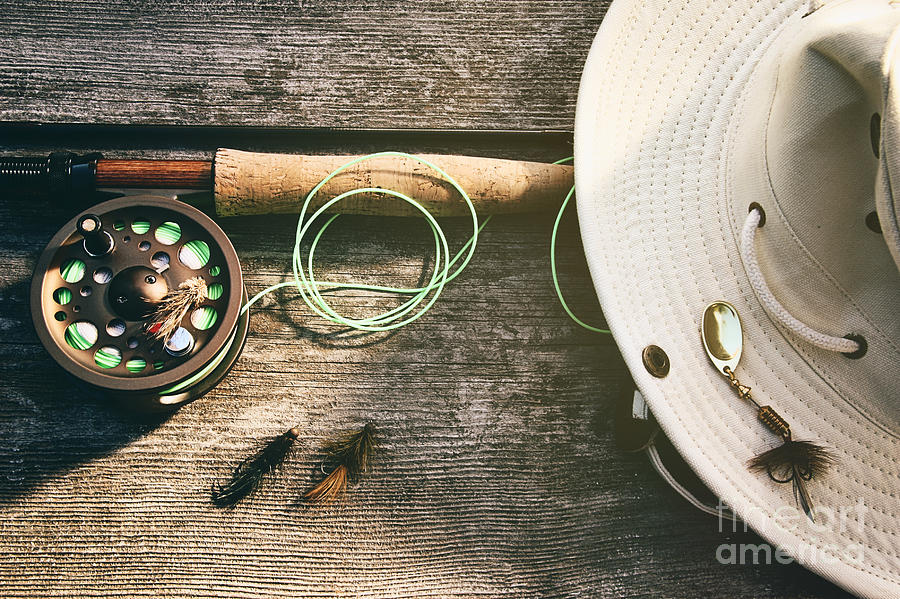 Fly fishing rod with hat on wood Photograph by Sandra Cunningham
