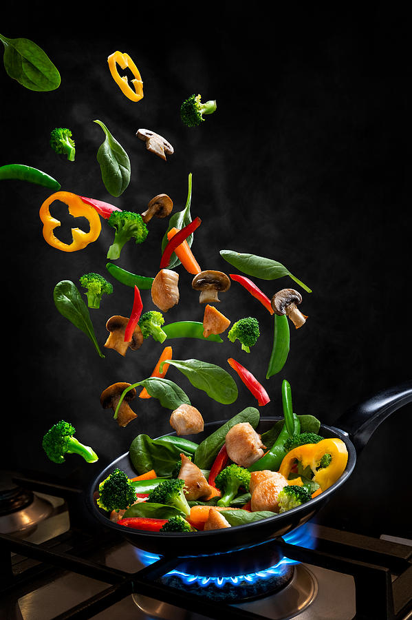 Flying Chicken and Vegetable Stir fry, into a frying pan Photograph by CarlaMc