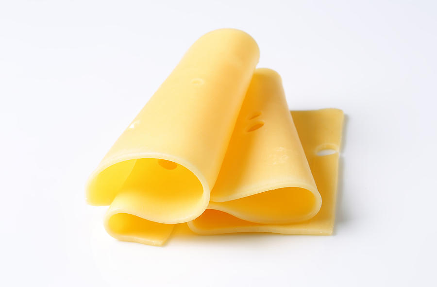 Folded slices of cheese on white background Photograph by Jaromila