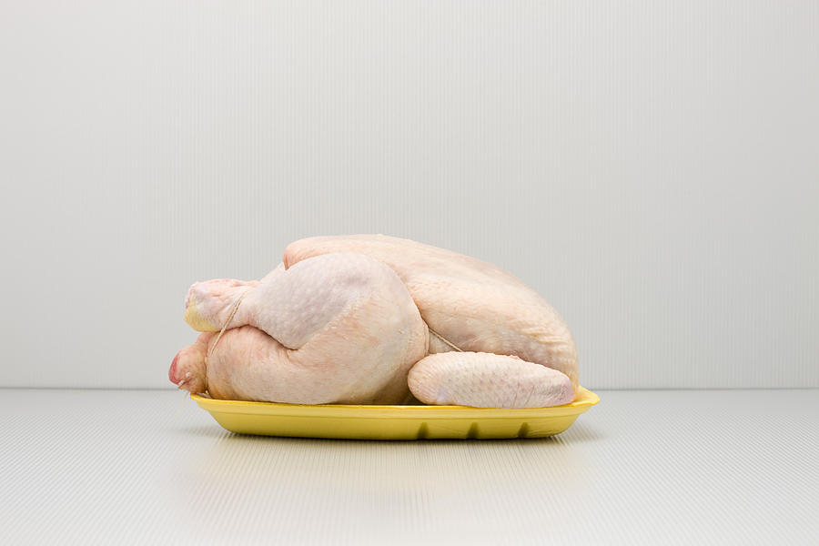 Food concept, raw whole chicken on polystyrene tray Photograph by PhotoAlto/Milena Boniek