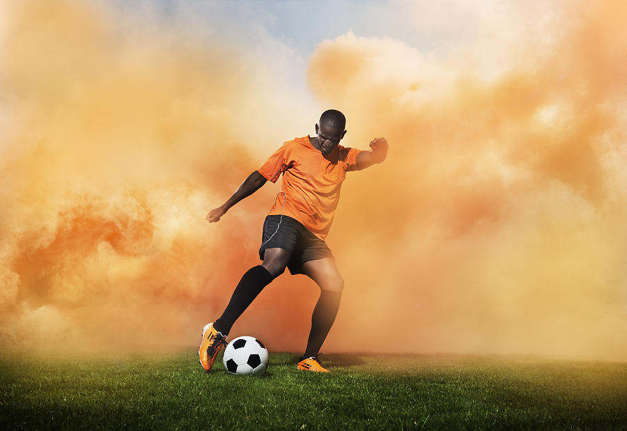 Football Player In Orange Smoke Photograph by Henrik Sorensen