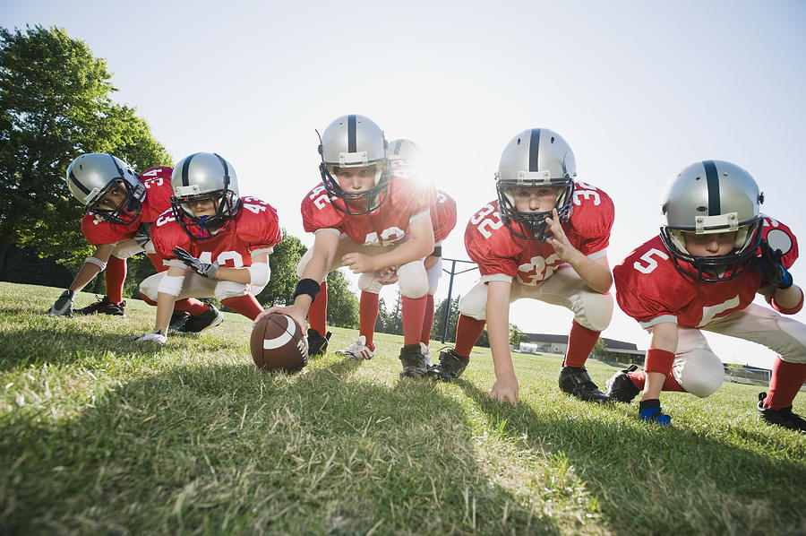 Football players at line of scrimmage ready to snap football Photograph by Tetra Images - Erik Isakson