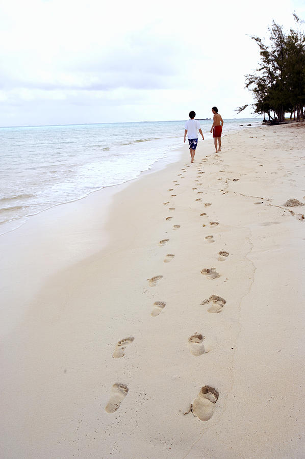Footprints in the Sand of Two People Walking Along the Beach Photograph by Dex