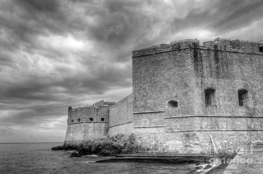 Fortified castle walls against a dramatic sky Photograph by Oscar Gutierrez