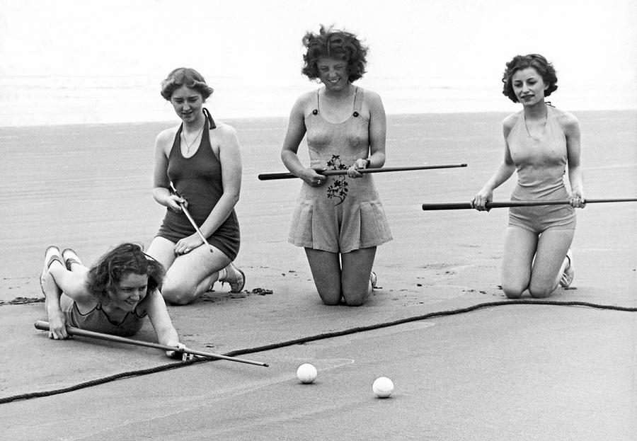 Black And White Photograph - Four Girls Playing Sand Pool by Underwood Archives