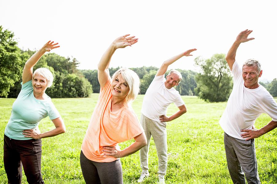 Four People In Field Exercising Photograph by Science Photo Library ...