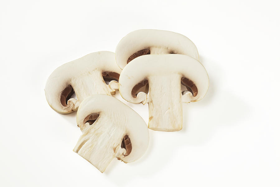Four white mushroom slices isolated on white Photograph by Atiatiati